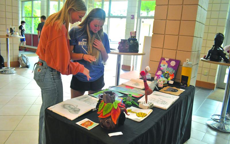 Megan Broome/The Clayton Tribune. Megan McKay and Jacie McCall view artwork at the showcase.