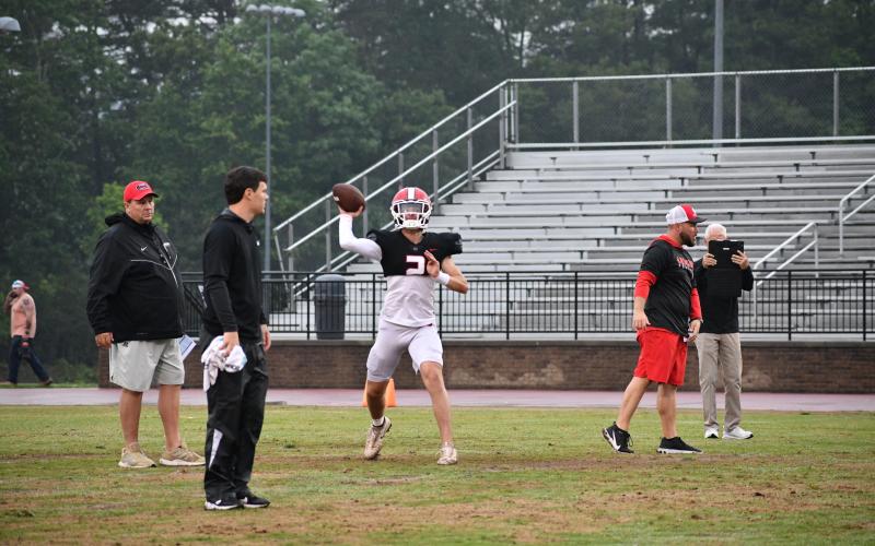 Luke Morey/The Clayton Tribune. Under the watchful eye of RCHS passing game coordinator Wes Holcombe, rising sophomore quarterback Ty Truelove releases a throw during the Spring Game session on May 18.