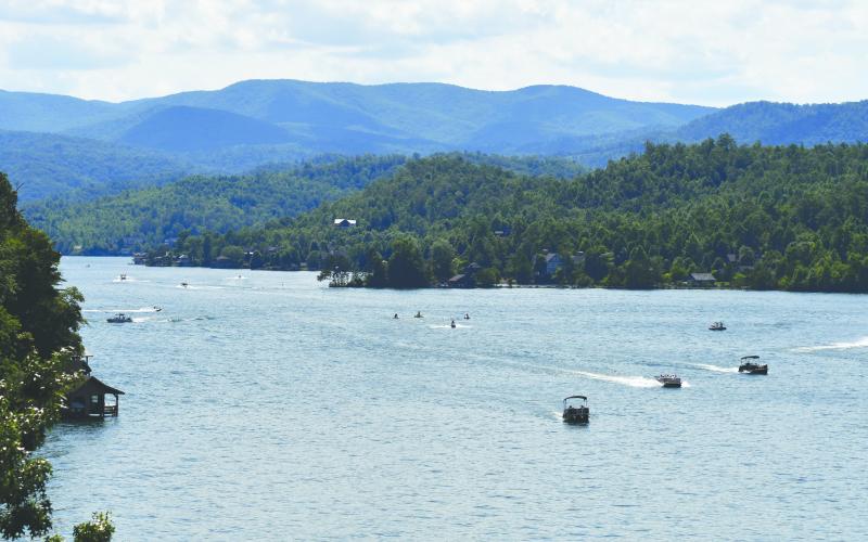 Enoch Autry/The Clayton Tribune. With the backdrop of Northeast Georgia mountains, boats navigate the waters of Lake Burton in Rabun County. The new legislation concerning wakeboarding and wakesurfing that was signed Tuesday by Gov. Brian Kemp will take effect on July 1 statewide just before the Independence Day weekend. The days around the Fourth of July is one of the busiest times of the year on the water. LBCA and LRA officials plan to provide information to boaters about the new law.