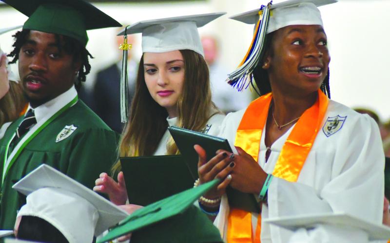 Enoch Autry/The Clayton Tribune. Seated next to Joey Lamm and Anastasia Lejava, Denika Lightbourne turns toward the crowd to see her family and friends celebrate her graduation from the Tallulah Fall School.