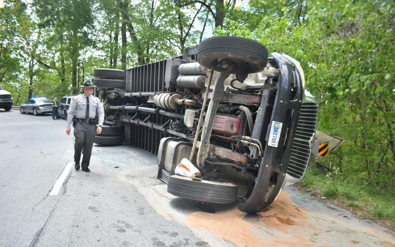 Megan Broome/The Clayton Tribune. North Carolina State Highway Patrol was dispatched to work the crash scene Monday, May 1 on Highway 246 in Macon County, North Carolina where a box truck hauling music equipment overturned and struck a guardrail.