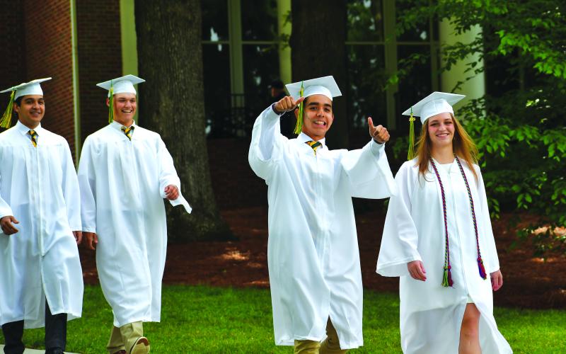 Luke Morey/The Clayton Tribune. Rabun Gap senior Hugo Garcia flashes two thumbs up next to Ella Jane Dow during the Class of 2023 graduation procession on Sunday, May 21. Garcia helped lead the Rabun Gap boys soccer team win back-to-back state titles.