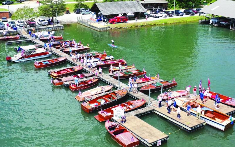 Submitted photo. Wooden Boats similar to these at Laprade’s Marina from a previous year will again be on display at this year’s show Sunday, May 28. Left: Photo courtesy Conner Horn.  Rabun County is the Wooden Boat Capital of Georgia and Lake Burton Wooden Boat owners hold up the sign at the May 12 Captain’s reception.