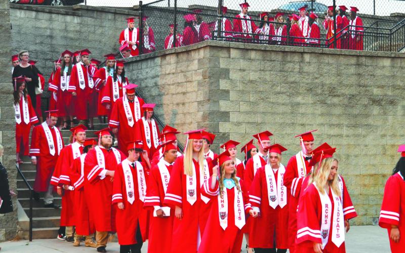Enoch Autry/The Clayton Tribune. The Class of 2023 walks past the rock into the stadium on May 26 for the RCHS graduation ceremony.
