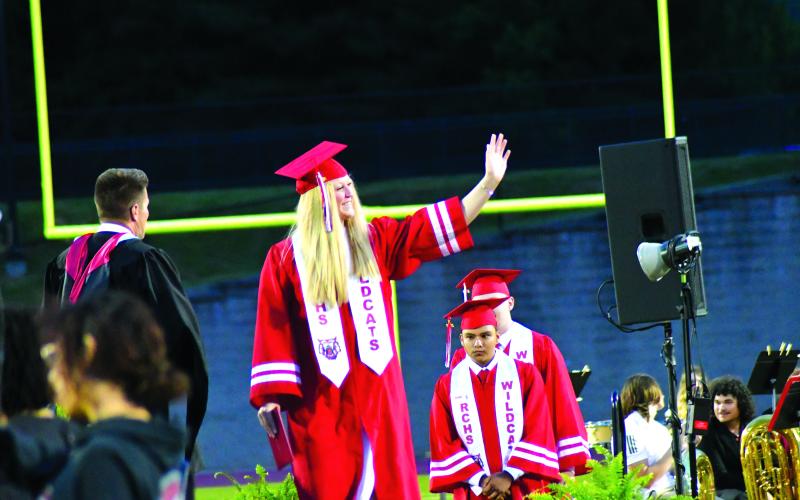 Enoch Autry/The Clayton Tribune. Upon receiving her diploma, graduate Hailey Smith waves to family and friends.