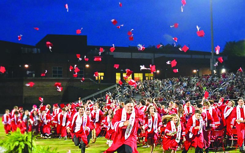 Enoch Autry/The Clayton Tribune. After Rabun County High School Principal Justin Spillers announces the Class of 2023 are graduates, the student body rush to ring the bell at Frank Snyder Memorial Stadium.