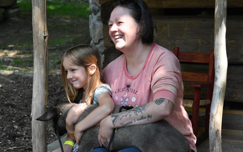 Enoch Autry/The Clayton Tribune. Krystle St. German spends time with her 6-year-old daughter Ally. Left: Enoch Autry/The Clayton Tribune. Sisters Anna, 7, and Claire, 4, Miller play inside one of the small Foxfire structures that were built for children.