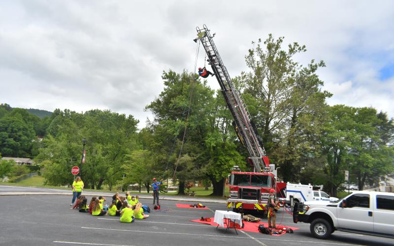 Megan Broome/The Clayton Tribune. Students watch as Rabun County Search and Rescue members rappel from the ladder truck while teaching students how they respond to emergencies and help people. Students also learned about Rabun County Fire Services and learn important fire safety tips during the event.