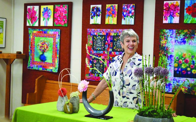 Megan Broome/The Clayton Tribune. Judy Cathey gives a special demonstration during the festival and speaks to the crowd about her love for floral arranging. She said her inspirations come from nature and Ikebana style of design. This piece is entitled “Kiss Rejected.”