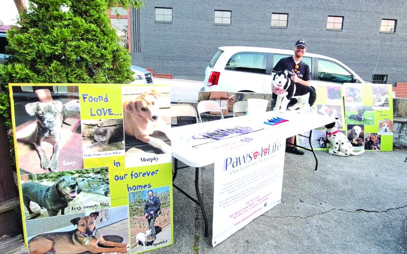 Megan Broome/The Clayton Tribune.  Everett Lampros, public relations, volunteer and adoption coordinator, mans the Rabun Paws 4 Life booth answering questions and providing information about the organization.