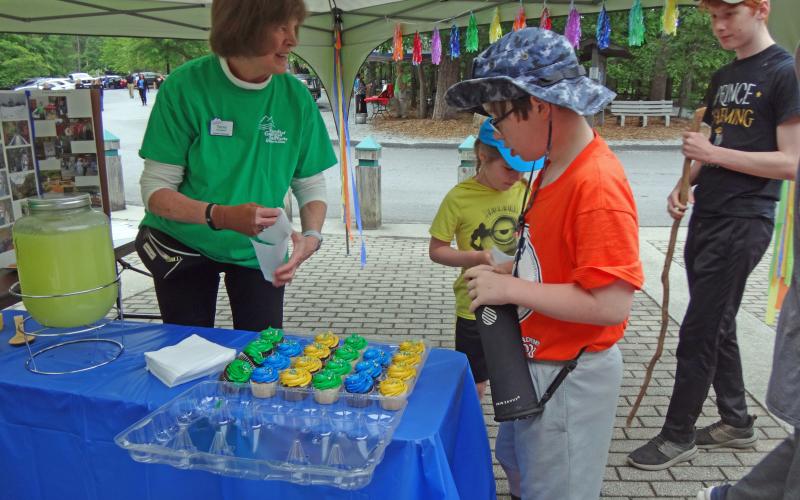 Submitted photo. Terry Knudsen, volunteer with Friends of TGSP, offers cupcakes and lemonade at the 30th anniversary celebration of the state park Saturday.