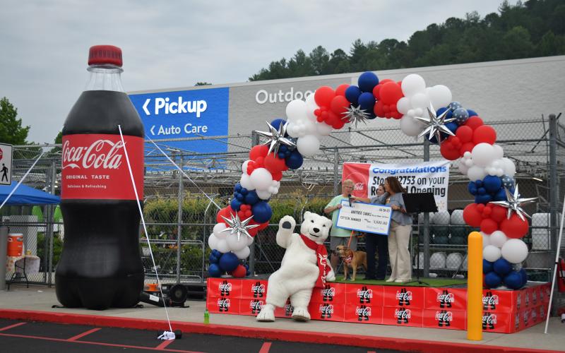 Megan Broome/The Clayton Tribune. Another Chance Rescue receives a $1,500 donation check from Walmart during the Clayton branch grand reopening June 30.