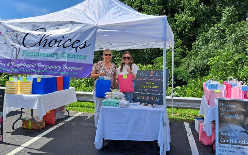 Megan Broome/The Clayton Tribune. Ann Key, assistant executive director, and Della Hunnicutt, office manager, for Choices Pregnancy Center distribute blankets and other items, as well as important information about resources and services the nonprofit offers during the Diaper Day Resource Fair held at the Rabun County Health Department Saturday, July 8.