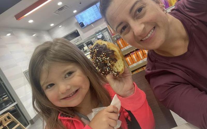Submitted. Locals Amber Owens and 5-year-old Rylee Owens are the first customers to enjoy doughnuts just before 5 a.m. at the new Dunkin’ Donuts in Clayton on opening day Thursday, July 13.