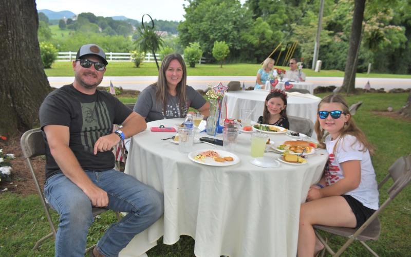 Megan Broome/The Clayton Tribune. The Bartlinski family from Florida-Jared; Kelly; Paisley, 9; and Brielle, 6, enjoy a cookout and live music by Hunter Grayson on the Oaklawn at The Dillard House to celebrate Independence Day July 3.