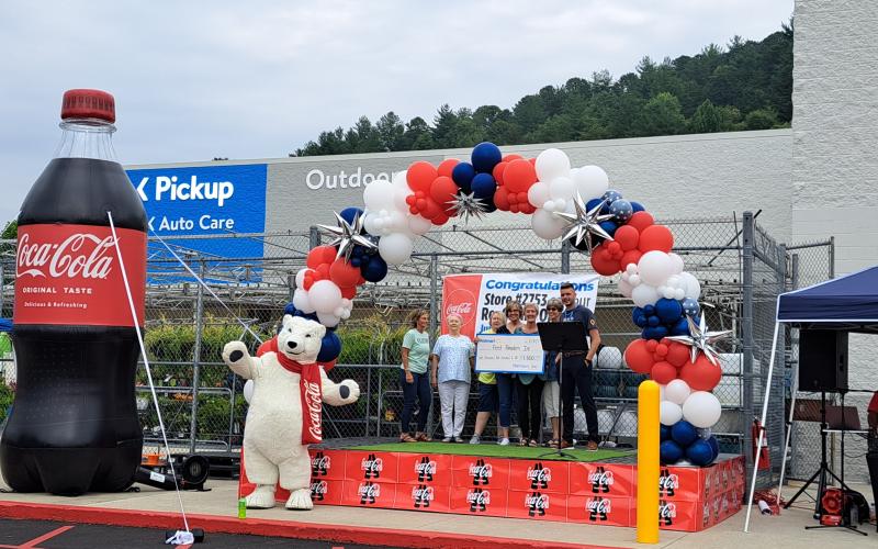 Megan Broome/The Clayton Tribune. Ferst Readers of Rabun County receives a $1,500 donation check from Walmart during the Clayton branch grand reopening June 30.