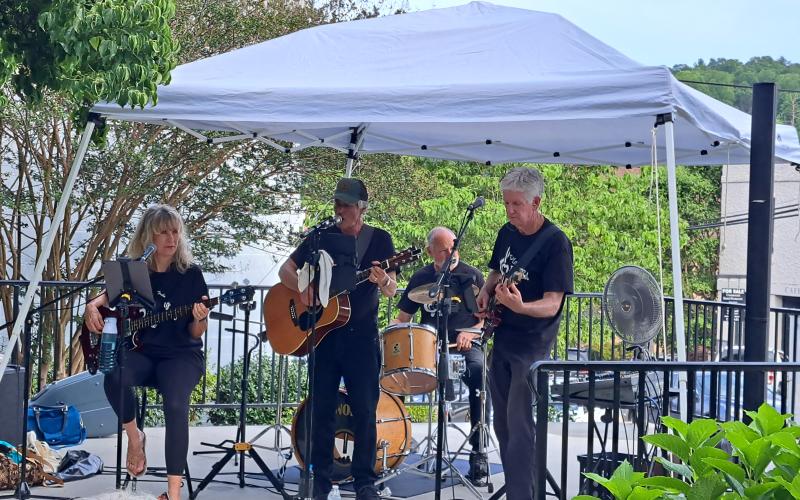 Megan Broome/The Clayton Tribune. The band “Playing it Forward,” which plays 100 percent for charity, performed during the First Friday Fest in Clayton July 7 during a fundraiser for Boy Scouts of America Troop 6. Musicians include Karen Bacon, David Bacon, Greg Presmanes and Bill Lisenby.