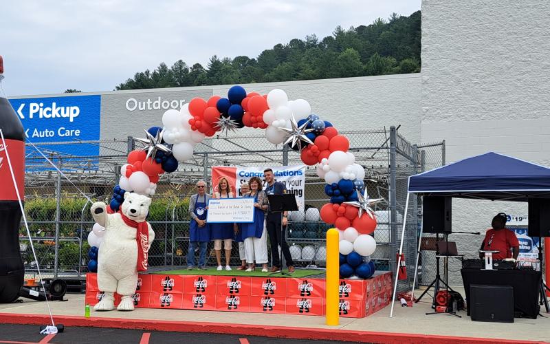 Megan Broome/The Clayton Tribune. Friends of the Rabun County Library receives a $1,500 donation check from Walmart during the Clayton branch grand reopening June 30.