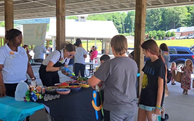 Megan Broome/The Clayton Tribune. Children enjoy natural fruit-flavored drinks at the hydration station to support healthy eating habits during the Happy Helpings launch, Georgia’s Food Service Program for Kids, at the pavilions behind Rabun County Public Library June 13.