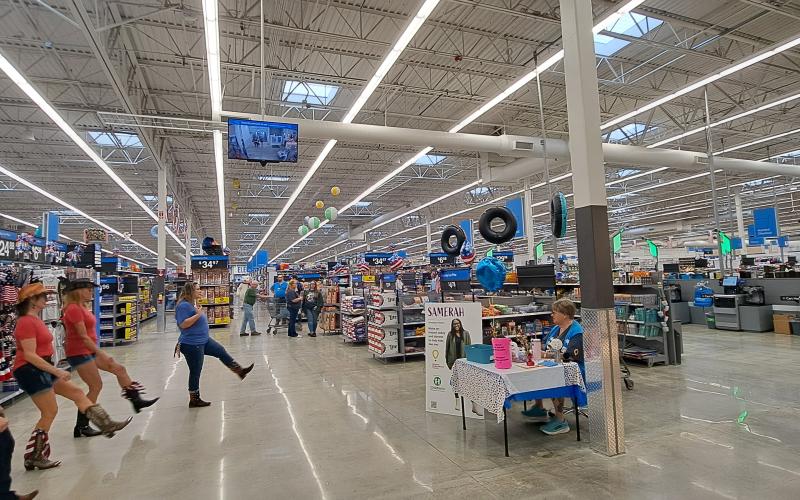 Megan Broome/The Clayton Tribune. The Line Dancing group “Neon Embers” performs in the lobby of the newly renovated Walmart Supercenter of Clayton during the grand re-opening event June 30.