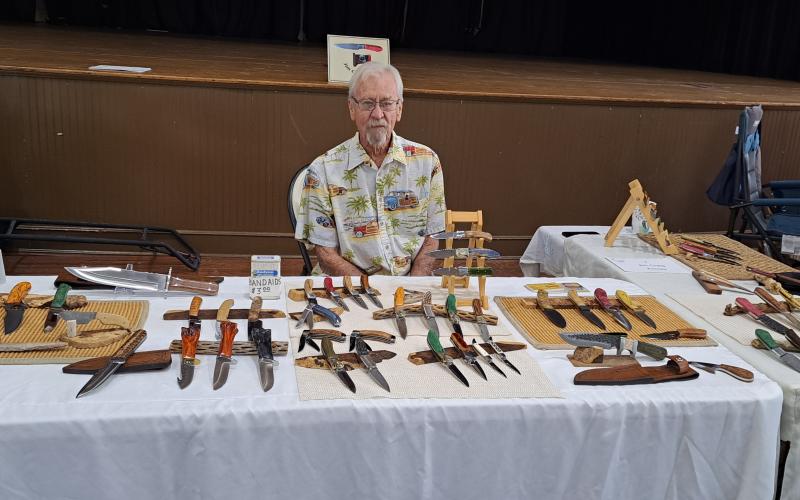 Megan Broome/The Clayton Tribune. Jim Craig showcases his Handcrafted Knives of Distinction at the Painted Fern Art Festival at the Rabun County Civic Center last weekend.