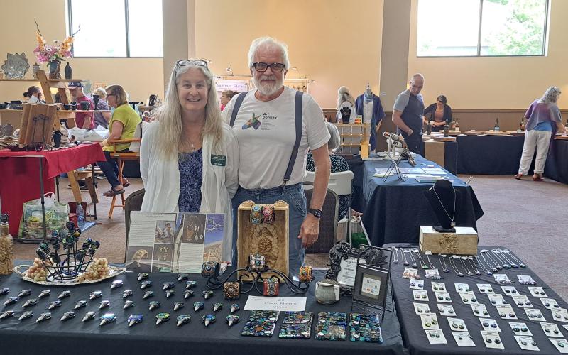 Megan Broome/The Clayton Tribune. Tallulah Falls residents Carol and Keith Nelms with Southern Lights Studio showcase unique glass art creations during the Painted Fern Art Festival last weekend.