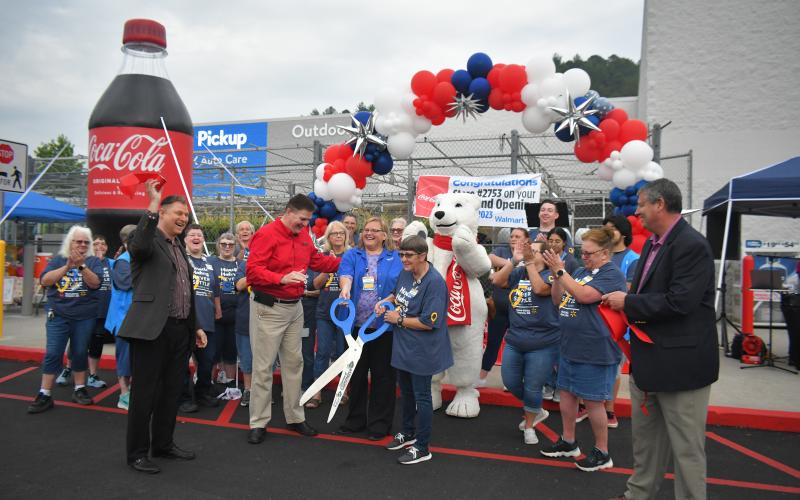 Megan Broome/The Clayton Tribune. Forward Rabun/Rabun County Chamber of Commerce celebrates with community members as they cut the ribbon on the newly renovated Walmart Supercenter in Clayton.