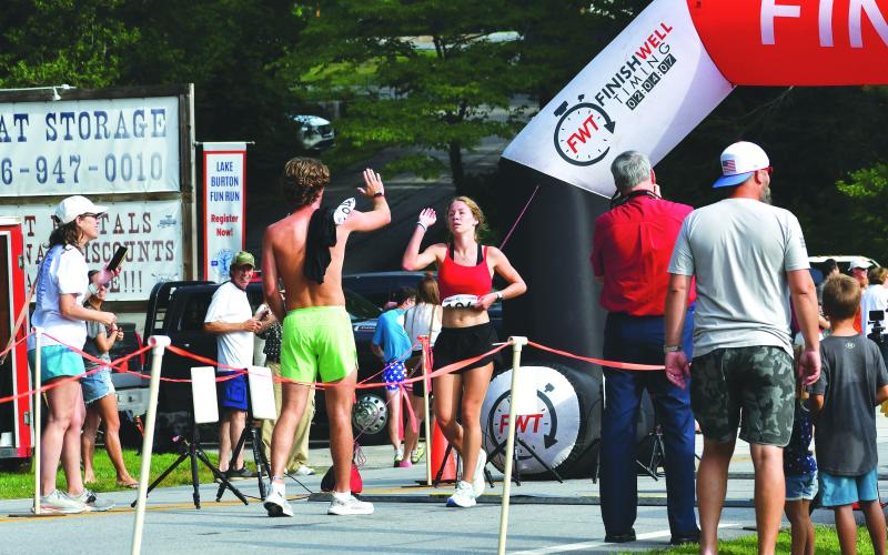 Luke Morey/The Clayton Tribune. Siblings Thomas and Audrey Hotard share a high five after finishing the Lake Burton Fun Run on Saturday, July 1. Audrey took the award as the top overall female runner while Thomas took fifth place overall.