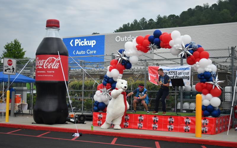 Megan Broome/The Clayton Tribune. Walmart Associate Tyler leads associates and community members in the Walmart Cheer during the store’s grand re-opening event June 30. The crowd was energized and enthusiastic as associates danced and cheered with the Coca-Cola polar bear to support the grand endeavor.