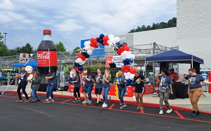 Megan Broome/The Clayton Tribune. Walmart associates dance and energize the crowd during the Walmart grand reopening event.