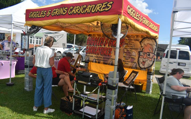Megan Broome/The Clayton Tribune. Giggles &amp; Grins Caricatures made its mark during the 26th Dillard Bluegrass Festival as attendees enjoyed having their inner characters drawn Friday, Aug. 4 and Saturday, Aug. 5.