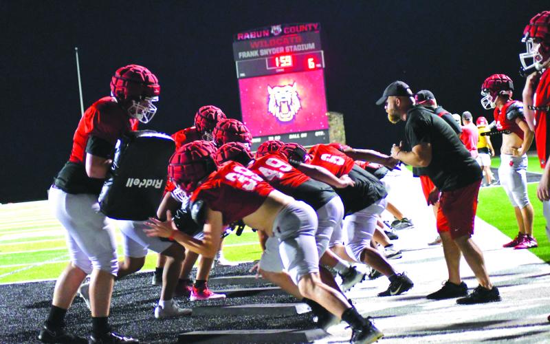 Enoch Autry/The Clayton Tribune. BATTLES ARE WON IN THE TRENCHES: The RCHS line comes quickly out of its stance to hit the pads.