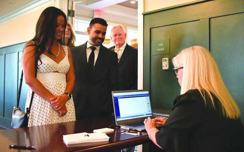Enoch Autry/The Clayton Tribune. Paul and Michelle Calez check in at the Green &amp; Gold Gala with Laura Schott, executive assistant to RGNS Head of School Jeff Miles.