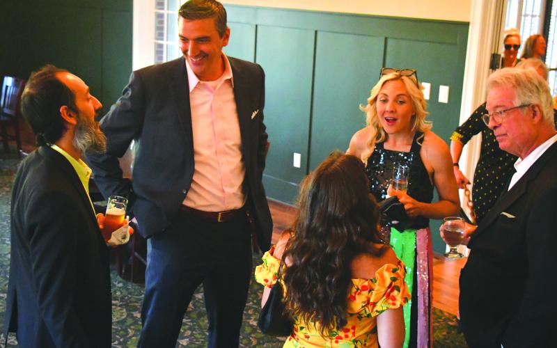 Enoch Autry/The Clayton Tribune. Mehran Ebadolahi (from left) talks with Rabun Gap-Nacoochee Head of School Jeff Miles as Andrea Sorgeloos and Keith Sorgeloos talk to guests at the Green &amp; Gold Gala in the Woodruff Dining Hall.