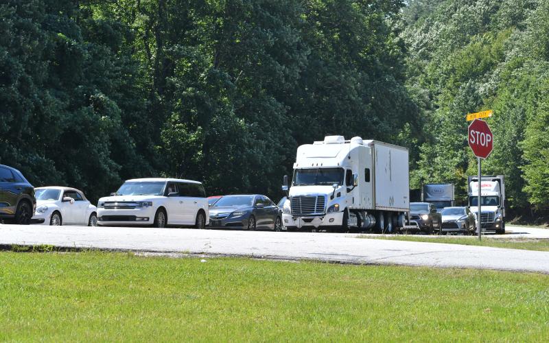 Megan Broome/The Clayton Tribune. Traffic was backed up for miles on Highway 441 southbound as both northbound and southbound travel lanes were shut down for hours due to a fatal two-vehicle crash Monday, July 31. Left: A memorial with flowers is displayed near the center aisles at the Clayton Ingles that reads “In Memory of Frank Hanrahan.” It also has information about a candlelight vigil that will be held Monday, Aug. 7 at 6:45 p.m. at the North end of the building.