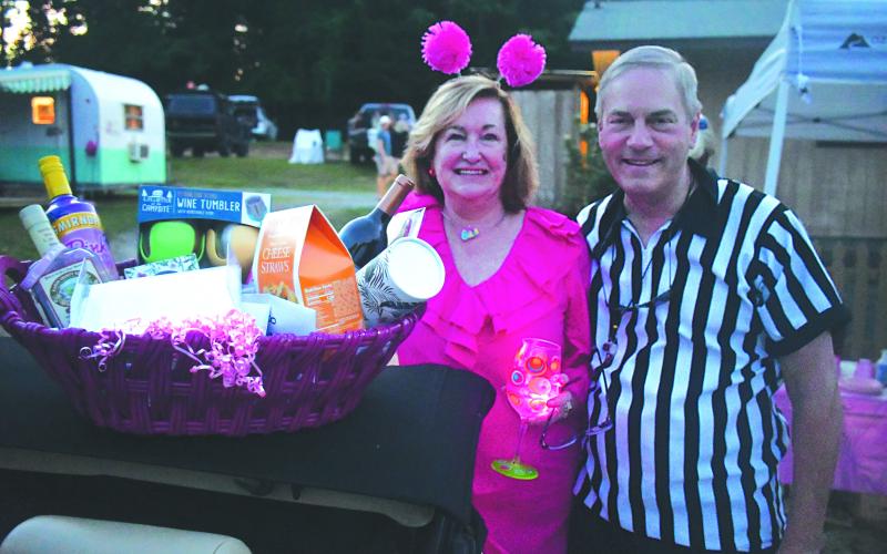 Enoch Autry/The Clayton Tribune. Standing with husband Referee Ken Chris Dunn, Deborah Dunn show her Entertainment Basket she won.