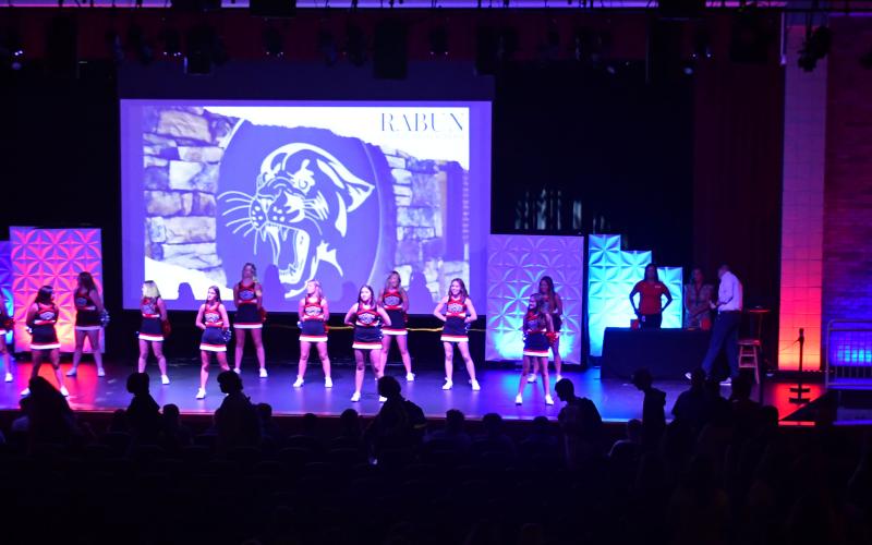 Enoch Autry/The Clayton Tribune. The Rabun County High School cheerleaders stand on the stage as the members of the Class of 2024 take their seats for the Tuesday pep rally. Below:RCES student Reese Dean selects the book “Ranger In Time” from the school library.