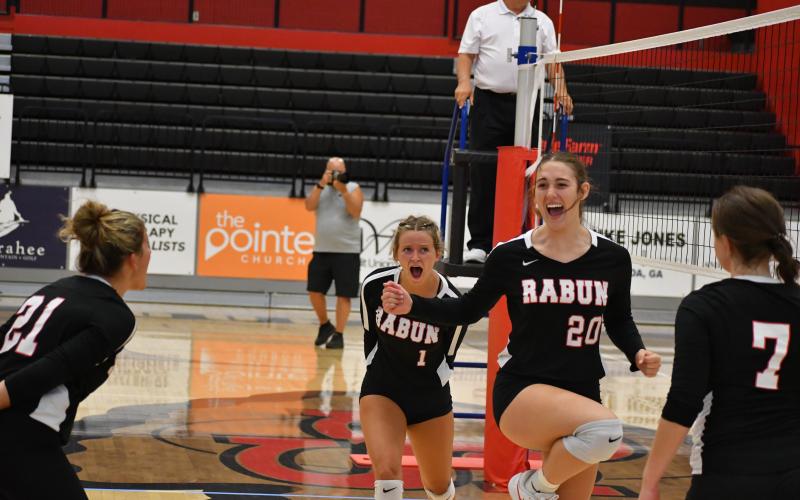 Wade Cheek/The Clayton Tribune. Lady Cat middle hitter Melanie Wells (20) celebrates with teammates after extending Rabun County's lead to five in the second half set against Stephens County on the road on Aug. 30.