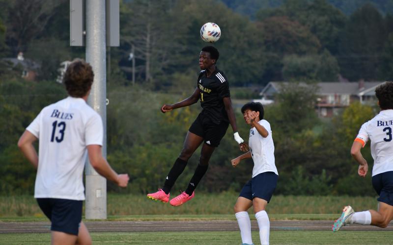 Wade Cheek/The Clayton Tribune. Eagle senior forward Theo Ochieng soars above Blues defenders for a header against region opponent Asheville School. RGNS is currently the No. 2 team in the NCISAA 4A division.