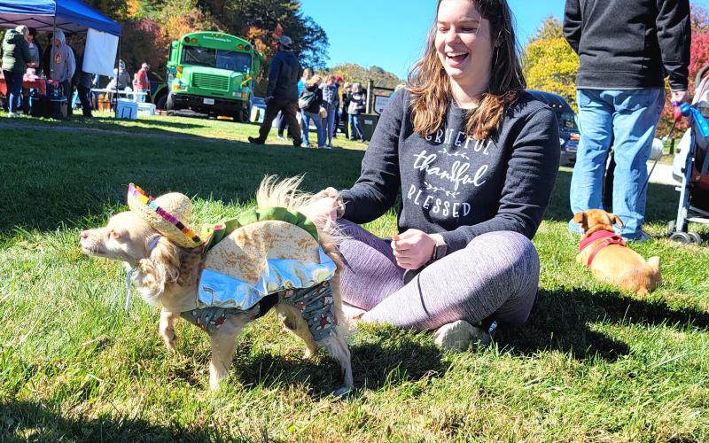 Enoch Autry/The Clayton Tribune. Peyton Lowery laughs at her dog Simba who dressed as a taco for the canine contest. Below: Third place in the Hay Bale Trail competition went to Bartram Trail Conservancy for their hay bale shaped like a shoe with animals that promoted hiking the trail and staying active.