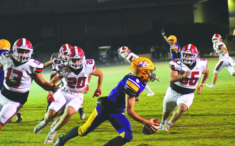 Wade Cheek/The Clayton Tribune. Athens Christian QB Matt Wiggins tries to avoid the Wildcats’ rush on Oct. 20 in a region contest won by RCHS 38-0. The Wildcats, who play Commerce this week, held the Eagles to negative 7 yards total offense.