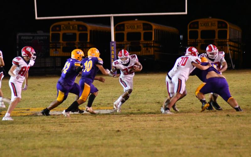 Wade Cheek/The Clayton Tribune. RCHS running back Kane Justice evades Athens Christian defenders on Oct. 20 as the freshman piled up 132 yards rushing and notched his first career touchdown.