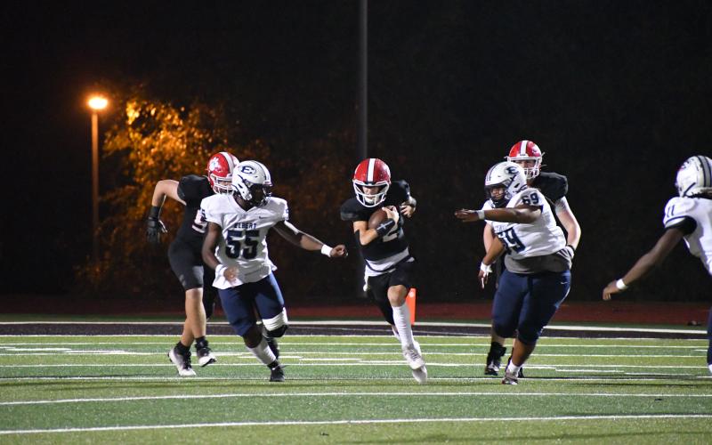 Wade Cheek/The Clayton Tribune. Wildcat quarterback Ty Truelove attempts to scramble out of pressure from the Blue Devil defense in last Friday’s 21-9 loss to Elbert County. RCHS dropped to the No. 5 ranking in Georgia Class A Division I after previously being ranked No. 4.