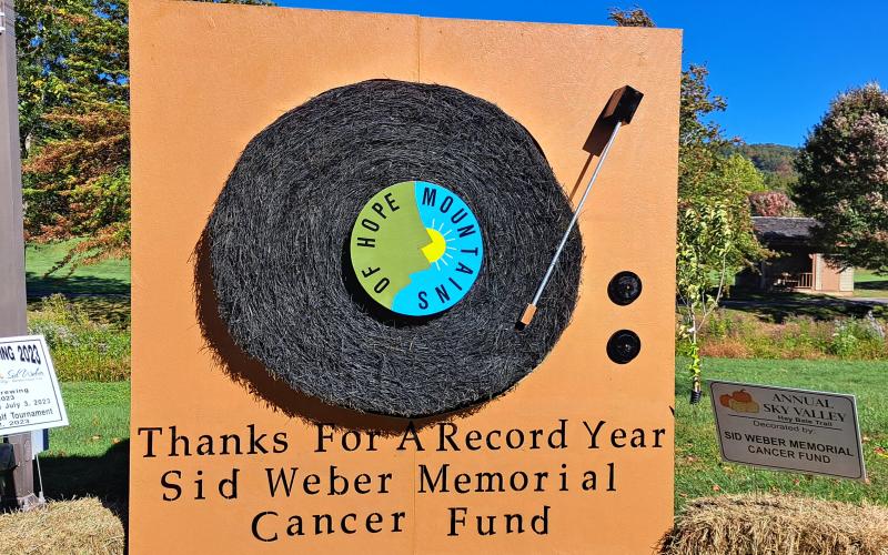 Megan Horn/The Clayton Tribune. 'Thanks for a Record Year' as Sid Weber Memorial Cancer Funds has a bale on the Hay Bale Trail in Sky Valley ahead of the Fall Festival. Left: Noryce and Don Burgey decorate a bale in the Sky Valley Hay Bale Trail for Bartram Trail Conservancy to bring awareness to and promote the 110-mile trail.