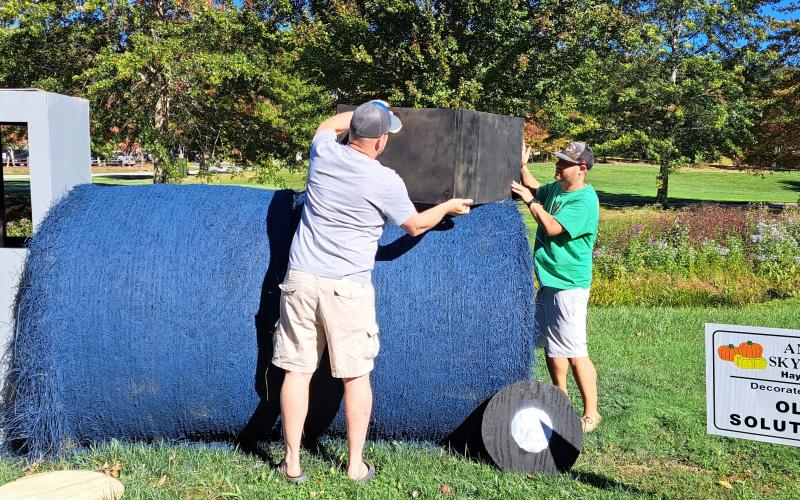 Megan Horn/The Clayton Tribune. Chip Oliver and Brandon Culpepper work on decorating a tractor for OLI Solutions as part of the Sky Valley Hay Bale Trail. Left: Noryce and Don Burgey decorate a bale in the Sky Valley Hay Bale Trail for Bartram Trail Conservancy to bring awareness to and promote the 110-mile trail.