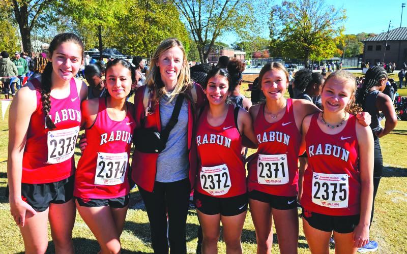 Submitted. The Lady Cat cross country team poses for a photo with their head coach April Adcock at last Friday’s state meet in Carrollton. The Lady Cats finished 14th in state despite many injuries and illnesses during the season.