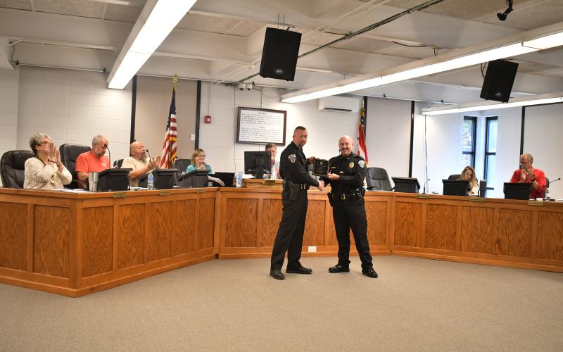 Megan Horn/The Clayton Tribune. Clayton Police Department Assistant Chief John Grist is recognized for 15 years of exemplary service to the city and is presented with a plaque by Chief Andy Strait on Oct. 17.