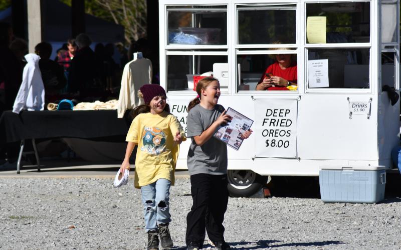 Enoch Autry/The Clayton Tribune. Hadley Cohee, 8, and Mary Vestal, 10, helped raised money for the RIPS Volleyball Scholarship Fund at the MarketPlace event. The girls went around the pavilions area asking people to enter a contest for meals at restaurants in the region.