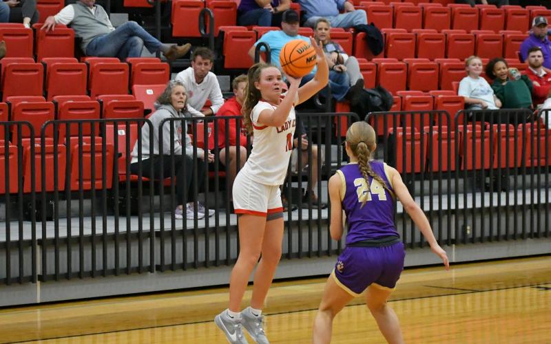 Wade Cheek/The Clayton Tribune. Western Carolina signee Lucy Hood releases her shot in a Lady Cat win over Union County Tuesday. In the background, Hood’s mother Amy Hood and RCHS head boys basketball coach David Adcock watch.