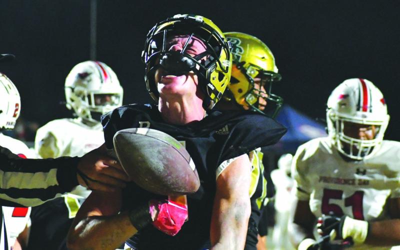 Wade Cheek/The Clayton Tribune. Rabun Gap’s Trey Horne, a Georgia Tech commit, vocally reacts after scoring a touchdown in the NCISAA state championship game as the referee reaches in grasp Horne’s arm with the ball. The Eagles fell 34-27 in the contest to Providence Day.